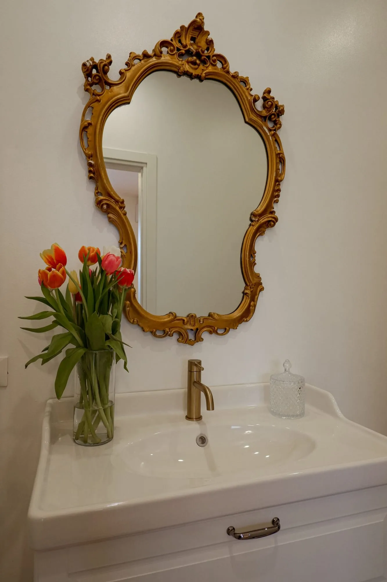 Lavabo con rubinetteria dorata e specchio barocco