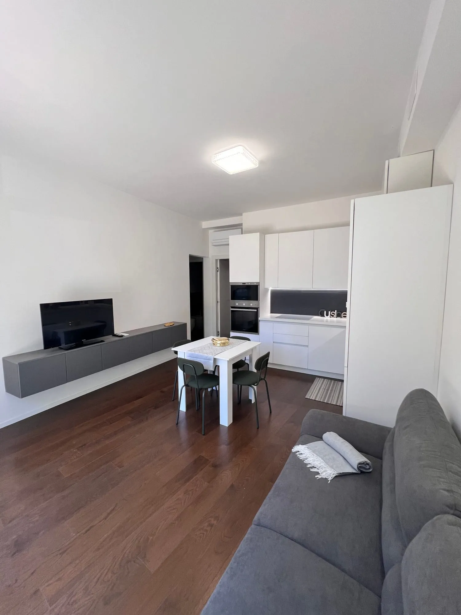 Soggiorno con TV e cucina sullo sfondo