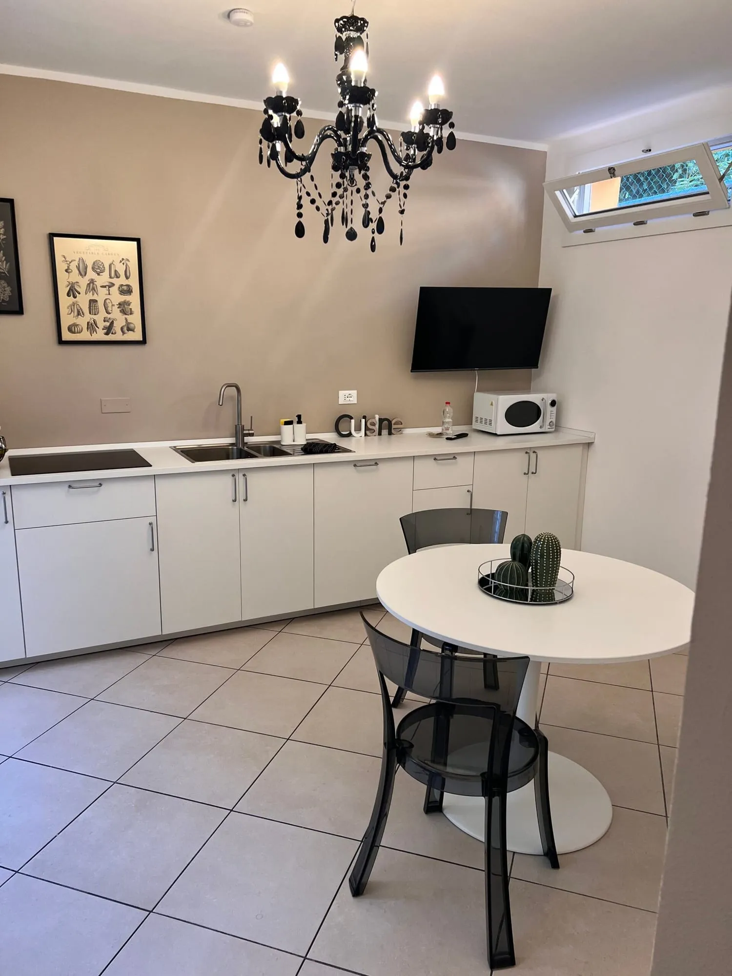 Cucina con piano cottura, microonde e TV